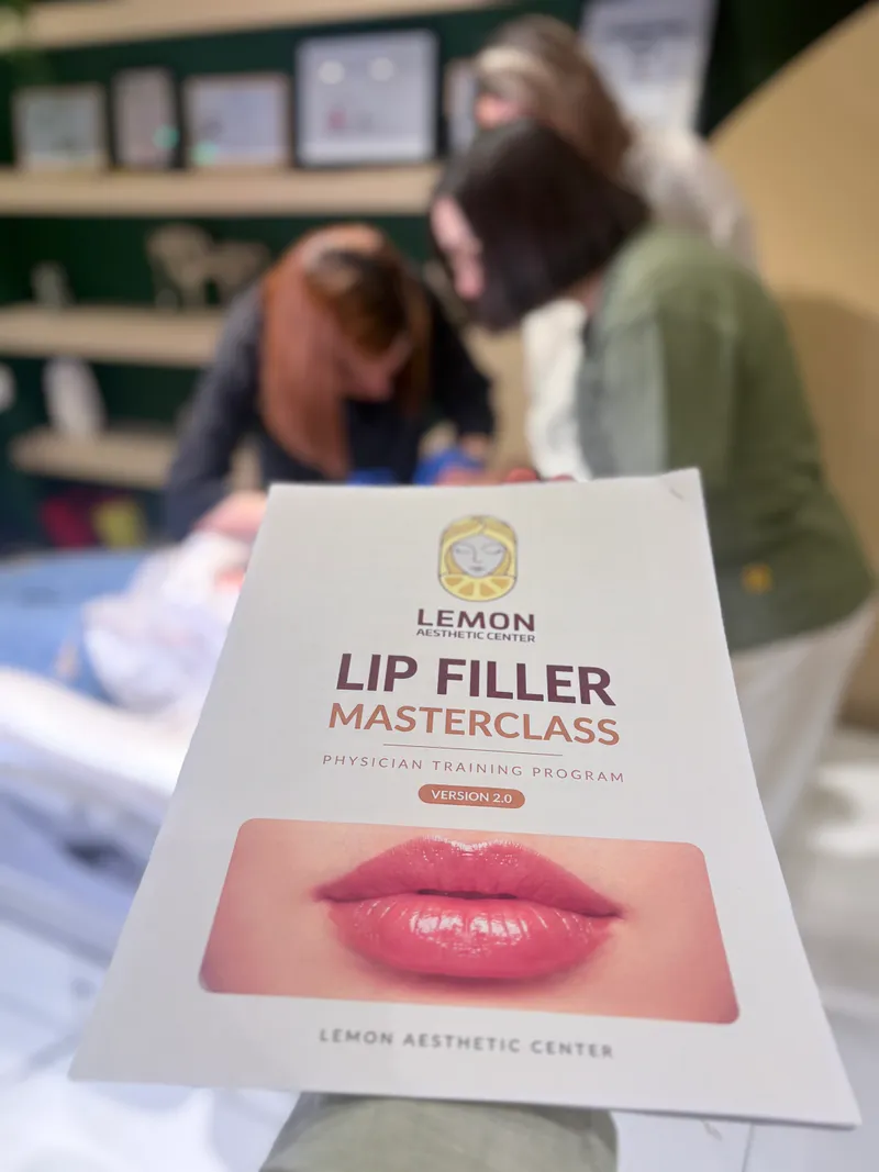 جزوه دوره مسترکلاس فیلر لب کلینیک لمون، پشت سرش کلاس آموزشی در حال کار روی مدل